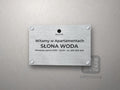 Srebrna tabliczka powitalna z logo obiektu i nazwą Słona Woda