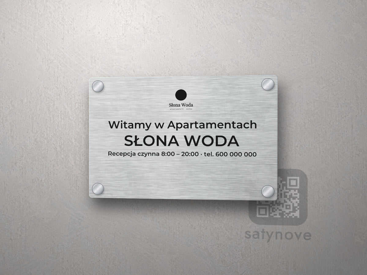 Srebrna tabliczka powitalna z logo obiektu i nazwą Słona Woda