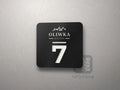 Czarna płytka z logo restauracji i numerem stolika 7