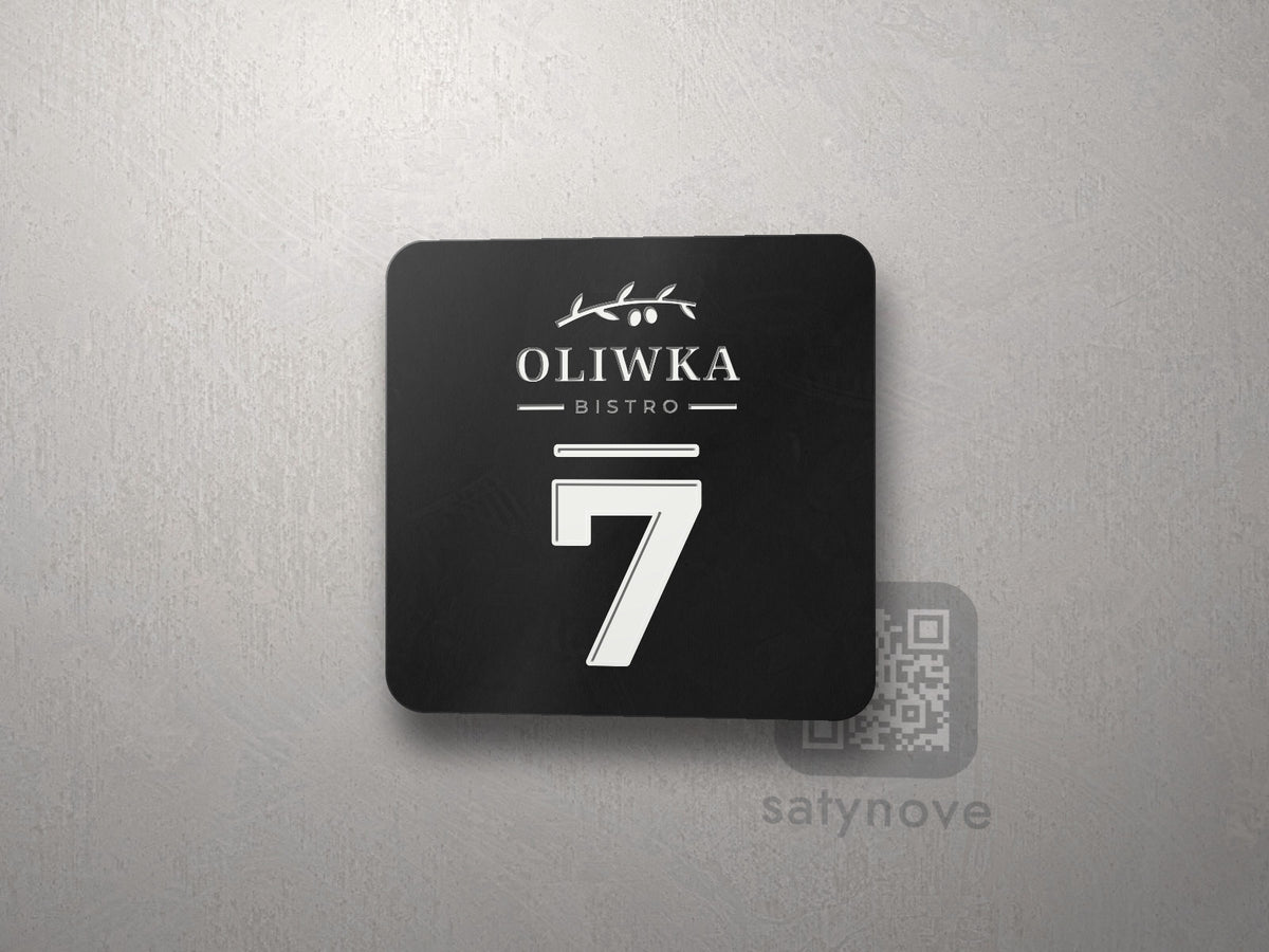 Czarna płytka z logo restauracji i numerem stolika 7