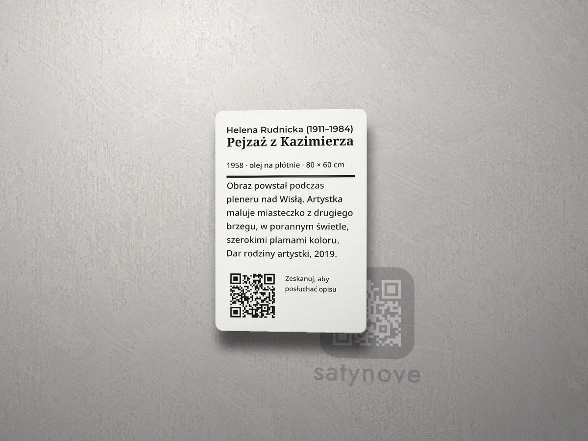 Pionowa tabliczka eksponatu: tytuł, opis, kod QR z podpisem na dole