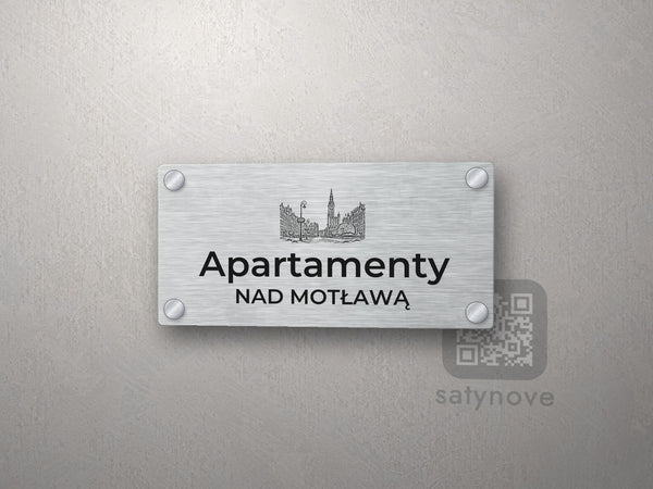 Srebrny szyld z grafiką Trójmiasta i napisem Apartamenty nad motławą