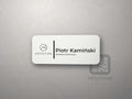 Biały identyfikator z logo firmy, imieniem i stanowiskiem