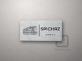 Srebrna tabliczka z rysunkiem i napisem SPICHRZ, pokój nr 2
