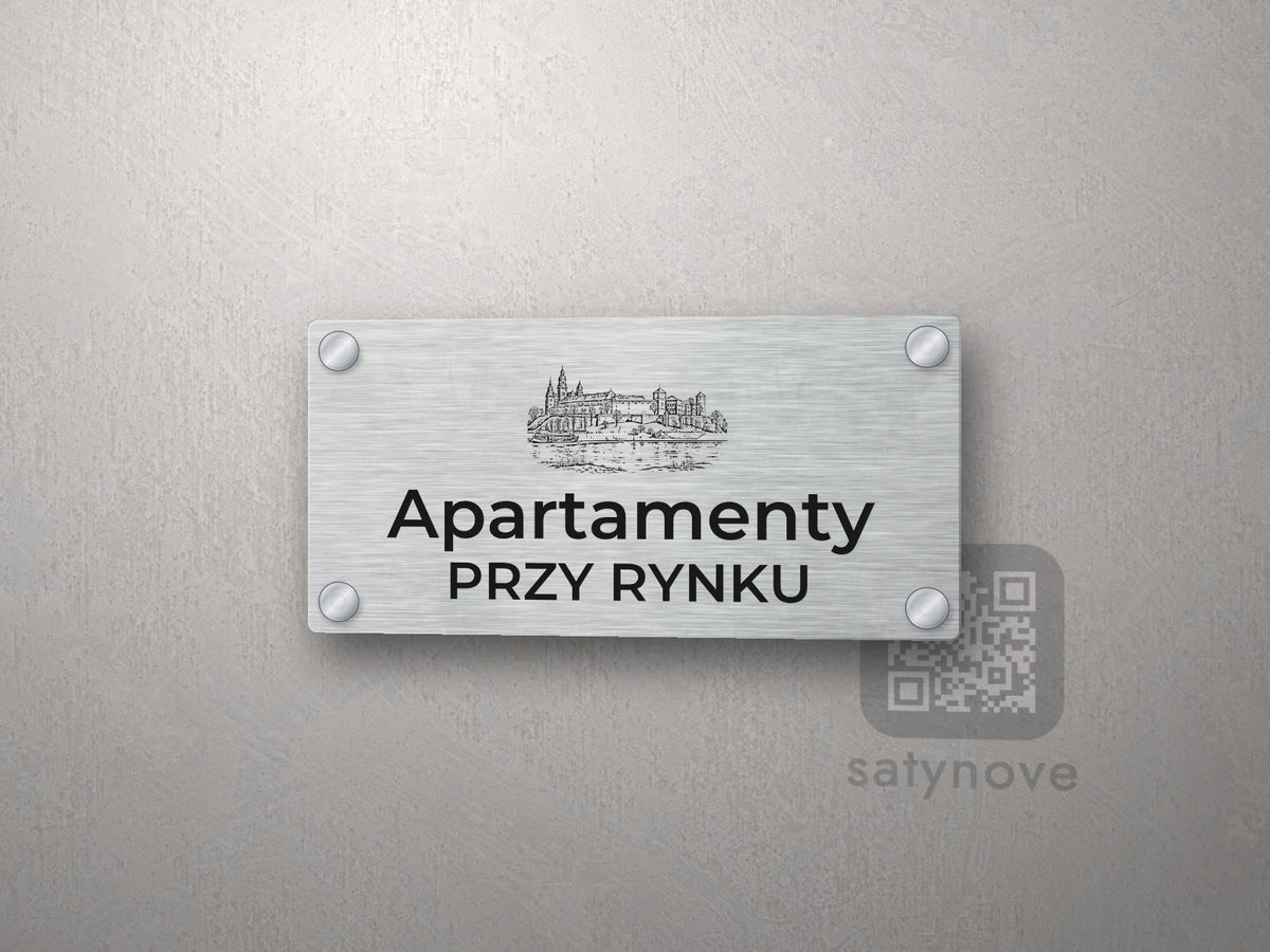 Srebrny szyld z grafiką Krakowa i napisem Apartamenty przy rynku