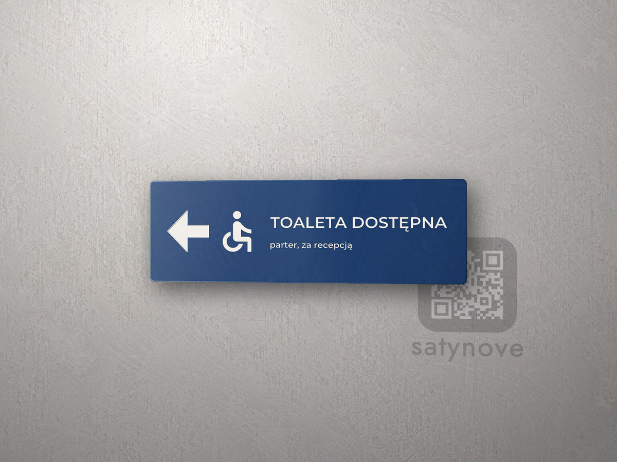 Tabliczka kierunkowa Toaleta dostępna ze strzałką w lewo i symbolem wózka