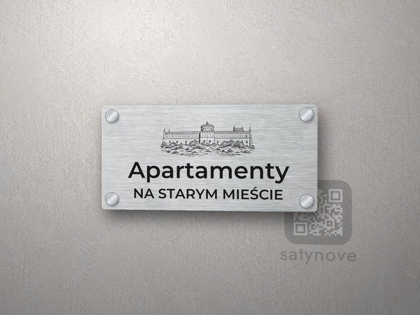 Srebrny szyld z grafiką Lublina i napisem Apartamenty na starym mieście