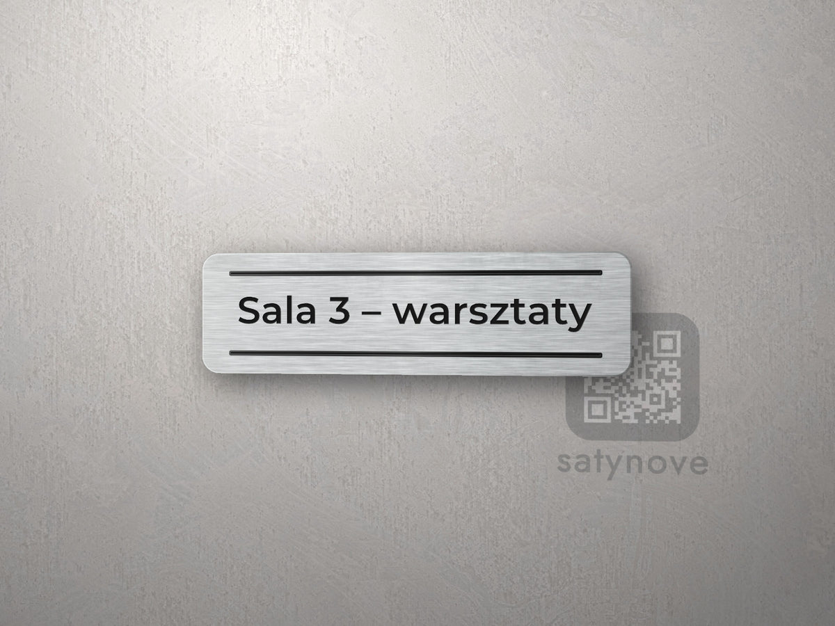 Mała srebrna tabliczka z napisem między liniami