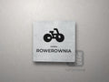 Kwadratowa tabliczka z piktogramem i podpisem ROWEROWNIA