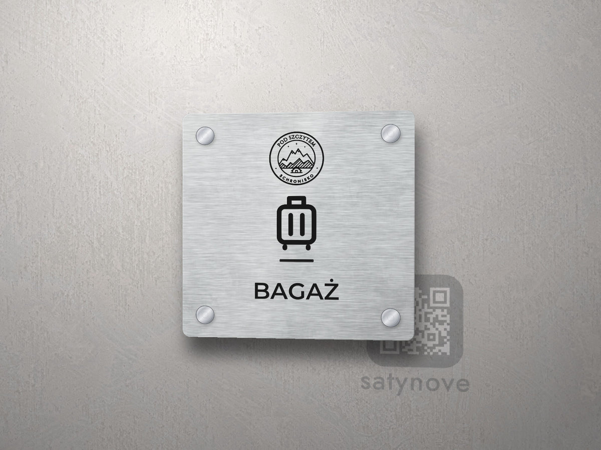 Srebrna tabliczka Bagaż z logo schroniska u góry, piktogramem i podpisem BAGAŻ