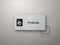 Srebrna tabliczka z piktogramem i napisem Pralnia