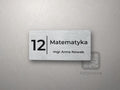 Srebrna tabliczka: numer sali 12, przedmiot Matematyka i nazwisko nauczyciela