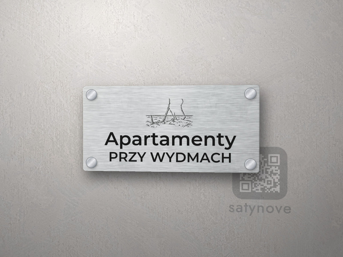 Srebrny szyld z grafiką Łeby i napisem Apartamenty przy wydmach