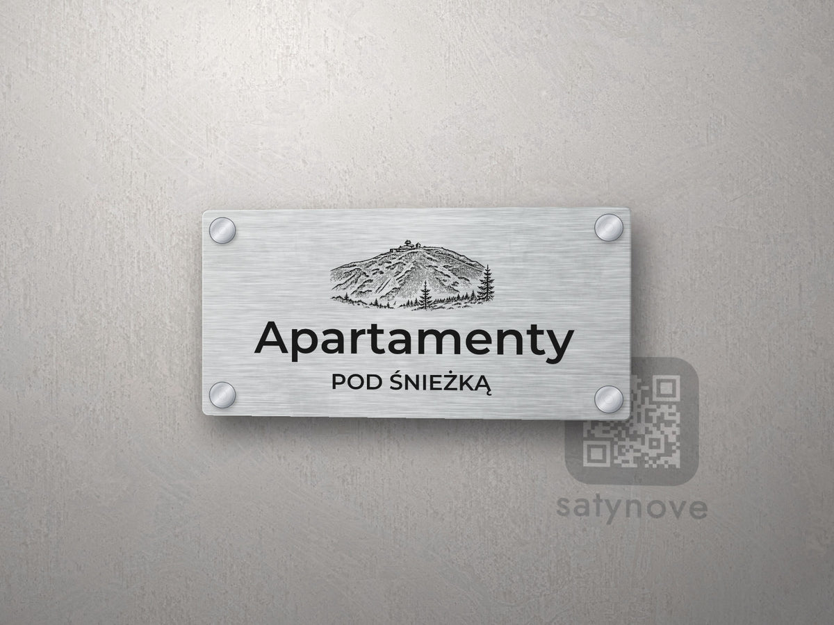 Srebrny szyld z grafiką Karkonoszy i napisem Apartamenty pod śnieżką
