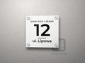 Kwadratowa tabliczka adresowa z numerem domu, linią i nazwą ulicy