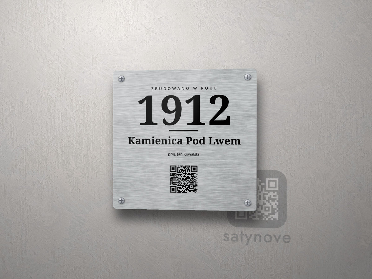 Kwadratowa tabliczka: napis ZBUDOWANO W ROKU, duży rok 1912, nazwa budynku i kod QR