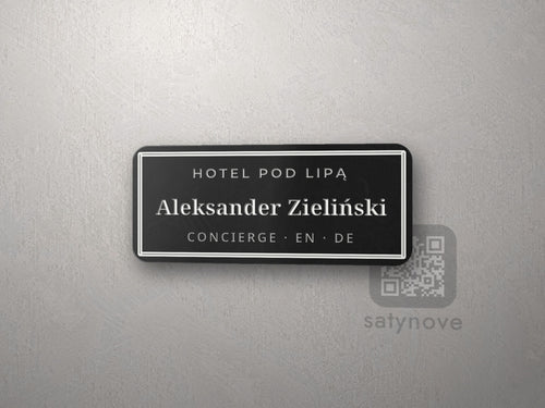 Czarny identyfikator w ramce z imieniem i stanowiskiem concierge