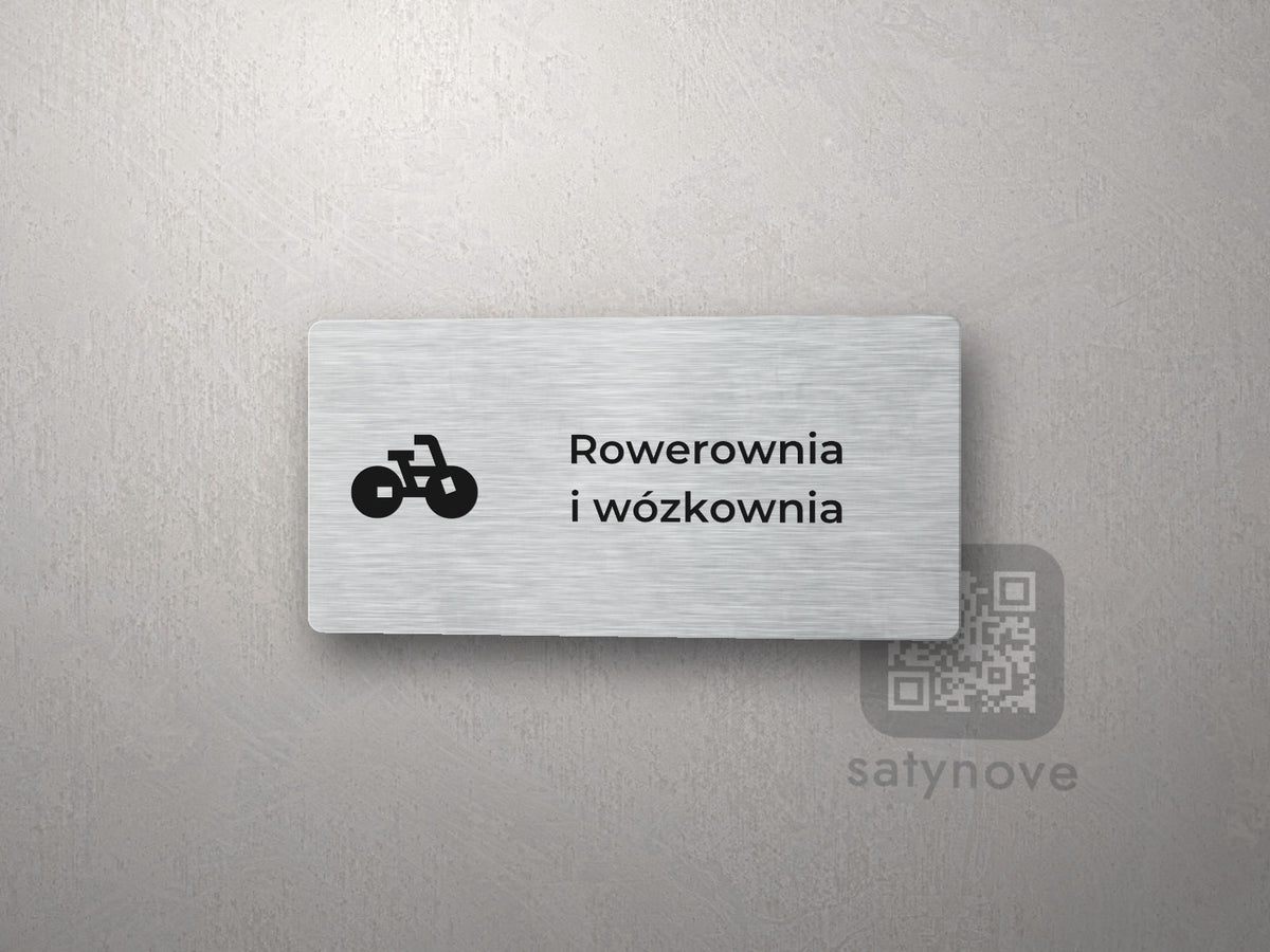 Srebrna tabliczka z piktogramem i napisem Rowerownia i wózkownia