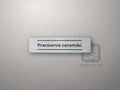Srebrna tabliczka z napisem „Pracownia ceramiki” między dwiema liniami