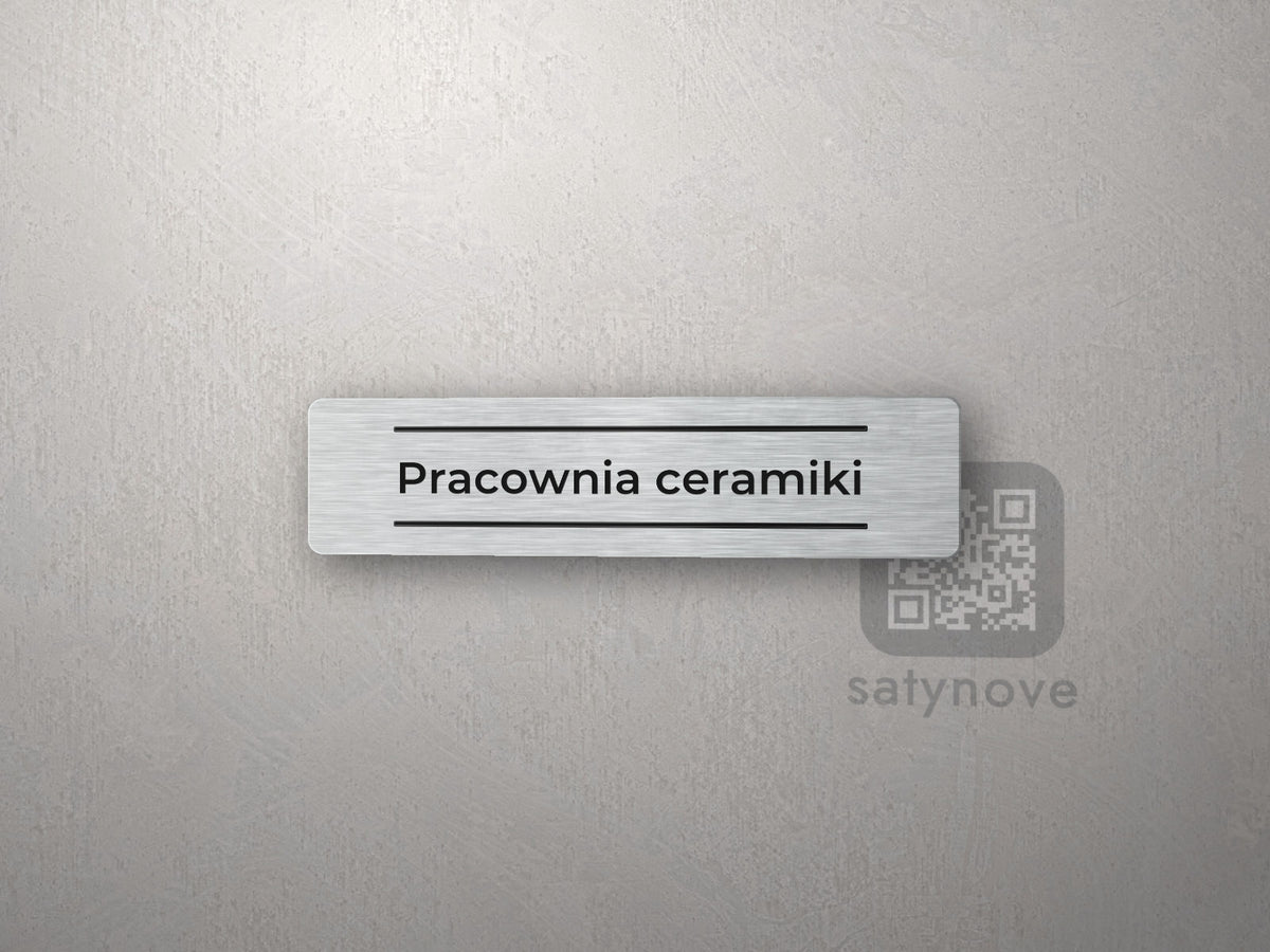 Srebrna tabliczka z napisem „Pracownia ceramiki” między dwiema liniami