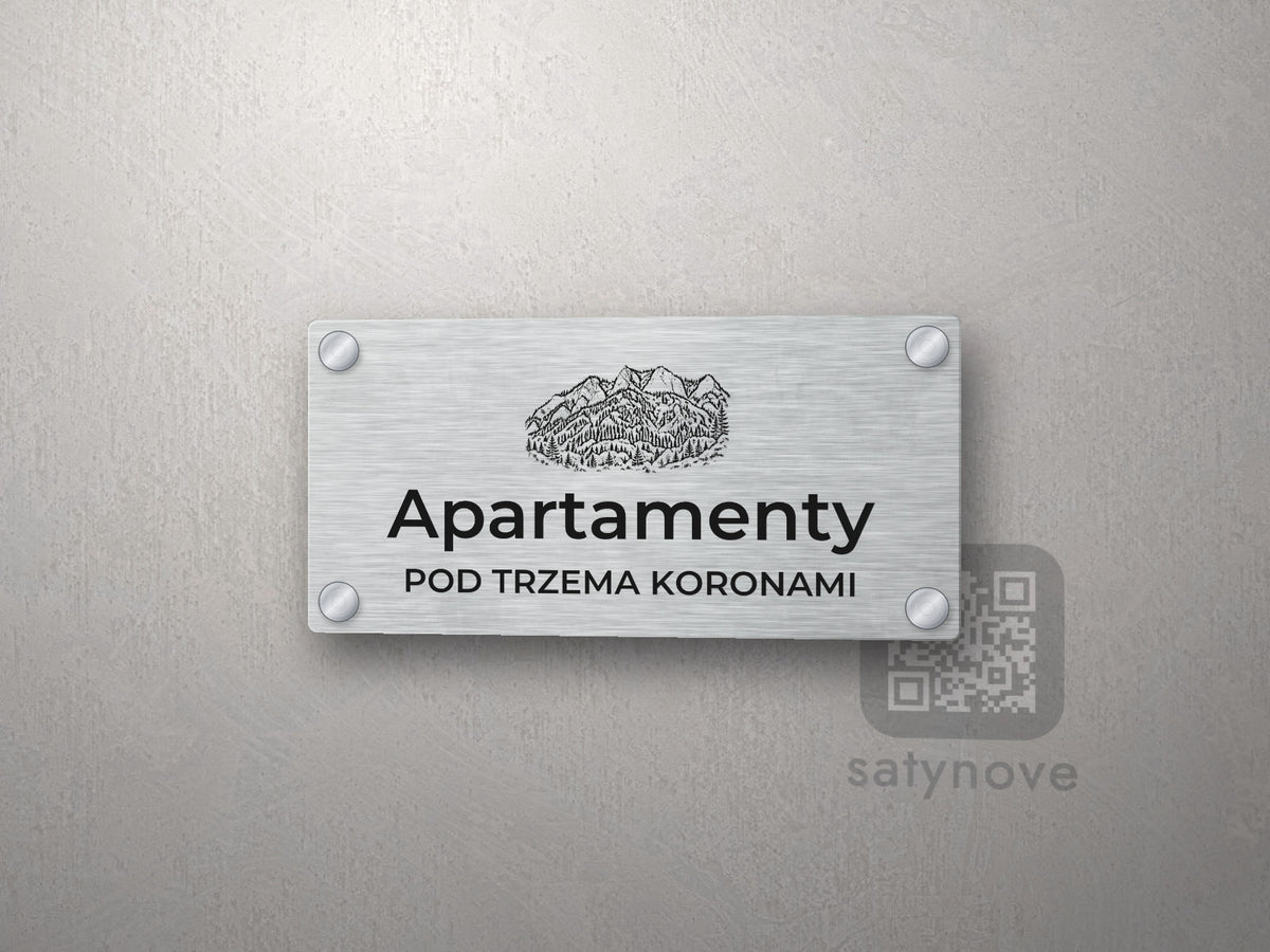 Srebrny szyld z grafiką Pienin i napisem Apartamenty pod trzema koronami