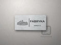 Srebrna tabliczka z rysunkiem i napisem FABRYKA, pokój nr 2