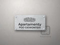 Srebrny szyld z rysunkiem Giewontu i napisem Apartamenty pod Giewontem