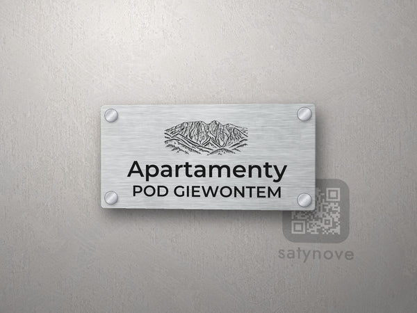 Srebrny szyld z rysunkiem Giewontu i napisem Apartamenty pod Giewontem