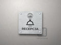 Srebrna tabliczka Recepcja z logo schroniska u góry, piktogramem i podpisem RECEPCJA
