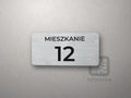 Tabliczka z napisem MIESZKANIE i numerem
