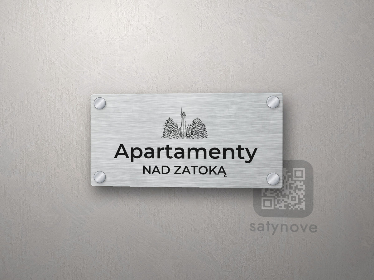 Srebrny szyld z grafiką Półwyspu Helskiego i napisem Apartamenty nad zatoką
