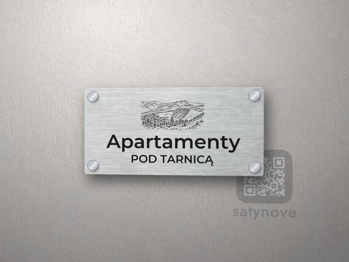 Srebrny szyld z grafiką Bieszczadów i napisem Apartamenty pod tarnicą