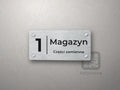 Tabliczka na drzwi z numerem 1 i napisem Magazyn, Części zamienne