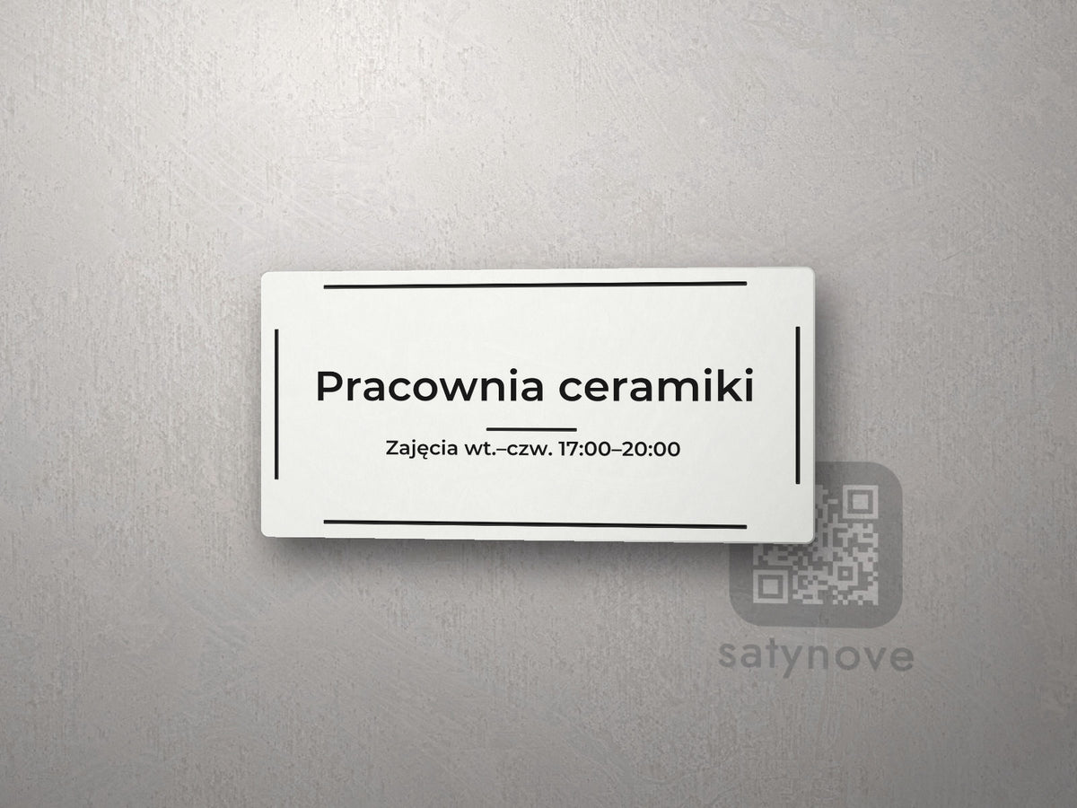 Biała tabliczka w ramce z napisem „Pracownia ceramiki” i dopiskiem