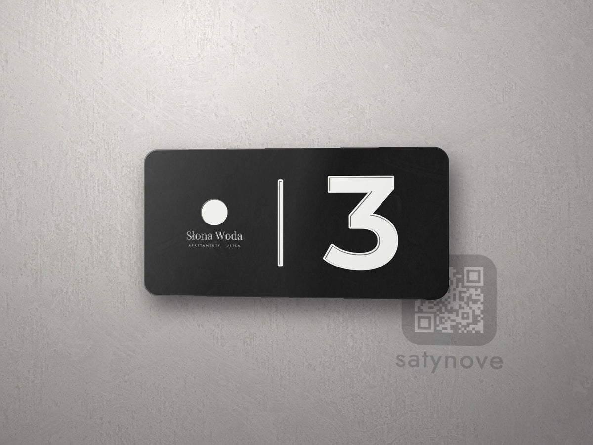 Czarna tabliczka z numerem 3 i logo obiektu