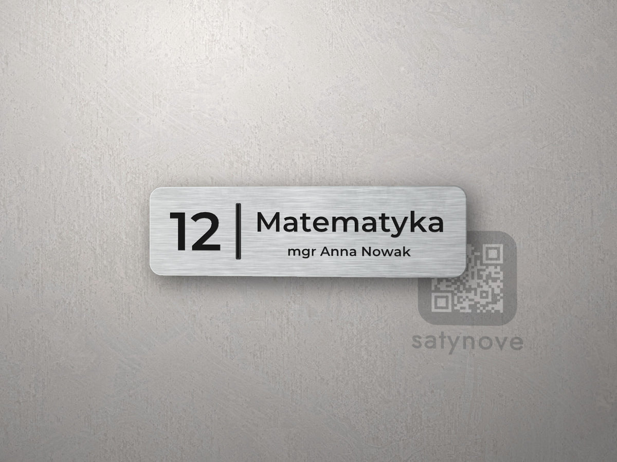 Mała srebrna tabliczka z numerem 12 i napisem Matematyka