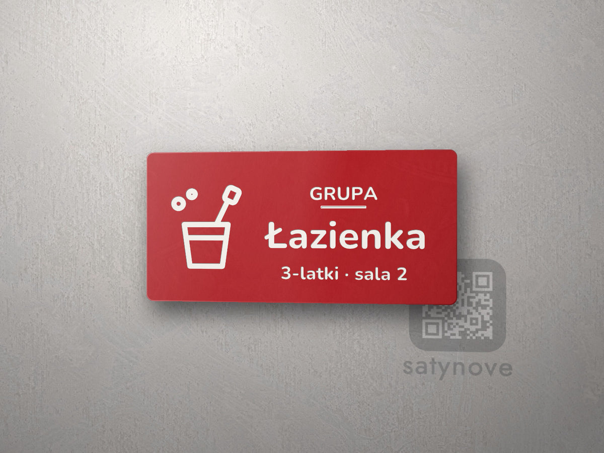 Czerwona tabliczka z obrazkiem i napisem Łazienka