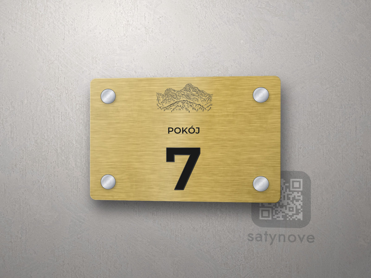 Złota tabliczka z numerem pokoju 7 i rysunkiem Rysów