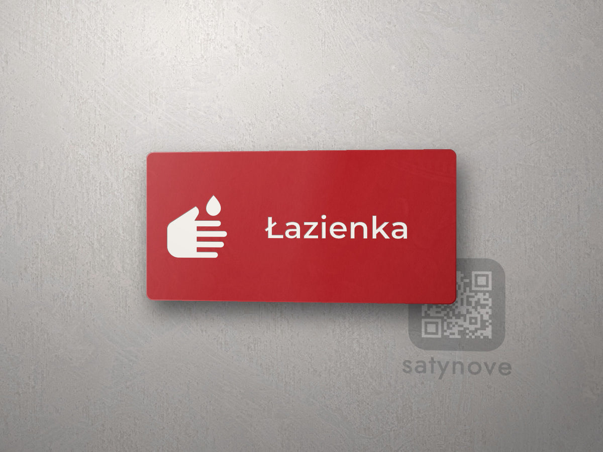 Czerwona tabliczka z piktogramem i napisem Łazienka