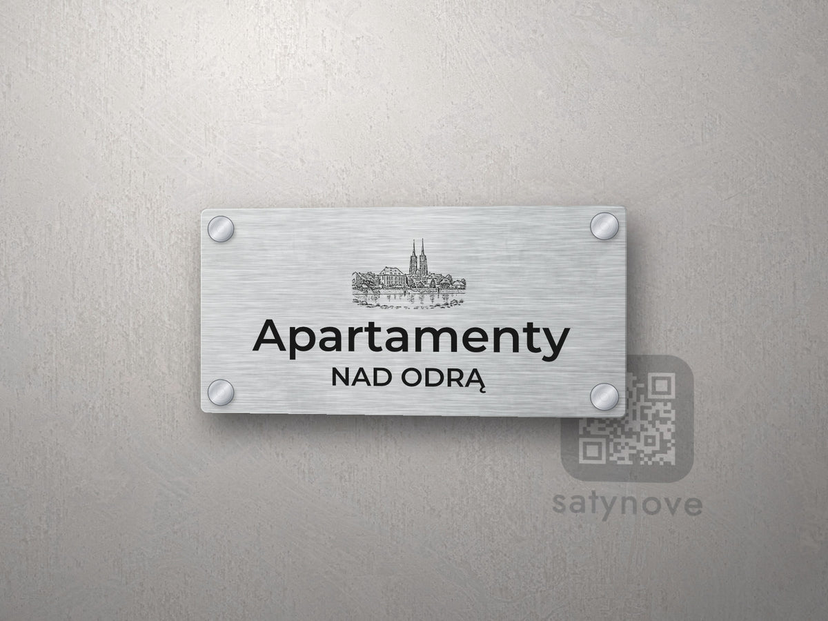 Srebrny szyld z grafiką Wrocławia i napisem Apartamenty nad odrą