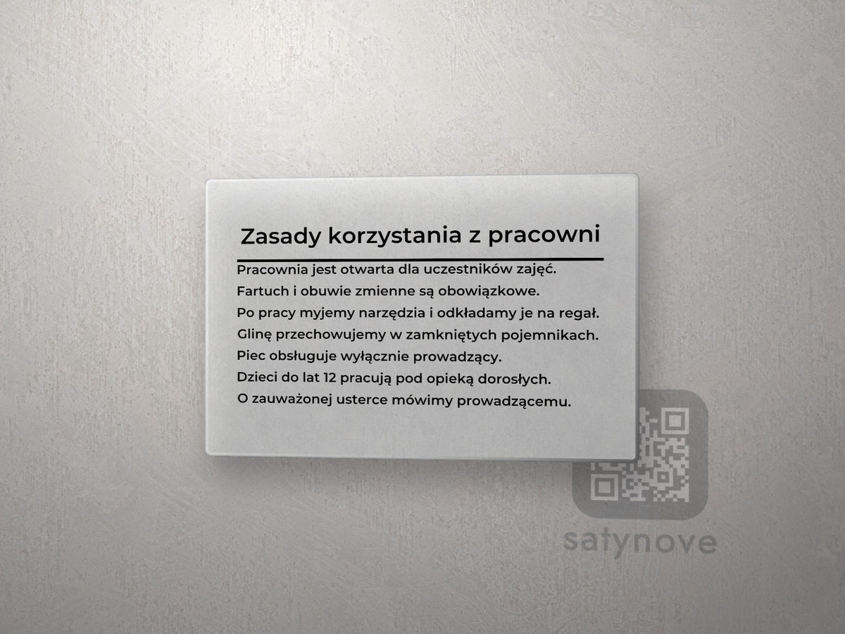 Tablica z plexi: tytuł „Zasady korzystania z pracowni”, linia i siedem zasad
