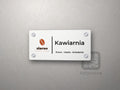 Biała tabliczka na drzwi z kolorowym logo kawiarni, napisem Kawiarnia i dopiskiem