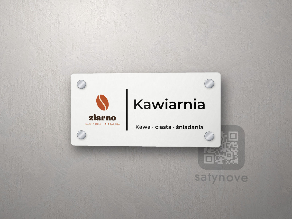 Biała tabliczka na drzwi z kolorowym logo kawiarni, napisem Kawiarnia i dopiskiem
