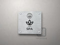 Srebrna tabliczka SPA z logo schroniska u góry, piktogramem i podpisem SPA